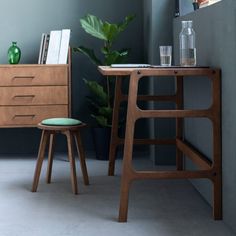 a chair and table in a room next to each other with plants on the side