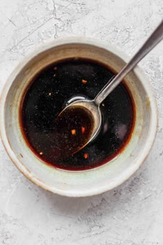 a spoon in a bowl filled with black liquid