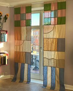 an open window with curtains and bookshelves in front of it, next to a book shelf filled with books