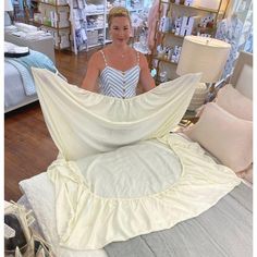 a woman standing next to a bed in a store