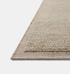 a beige rug is shown on a white surface with an area rug underneath the rug