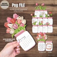 a hand holding a jar filled with flowers next to a calendar on a wooden table