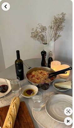 the table is set with wine, bread and other food items for an appetizer