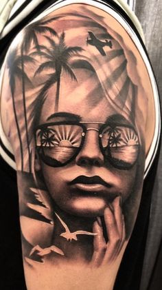 a woman with sunglasses and palm trees in the background is featured on this arm tattoo