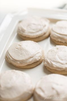 cookies with white frosting in a plastic container