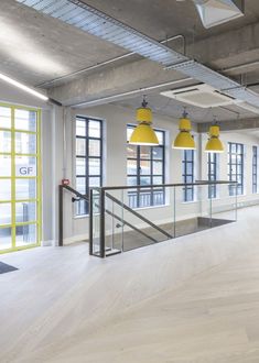 an empty room with yellow lights and wooden floors