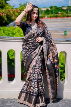 a woman in a sari waving at the camera