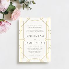 a wedding card with flowers and greenery next to it