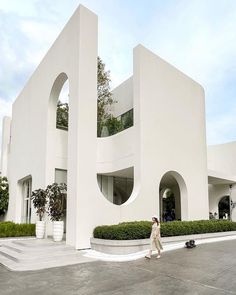 a person walking in front of a white building