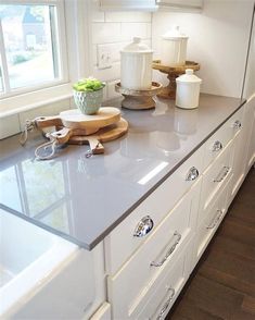 a kitchen with white cabinets and counter tops