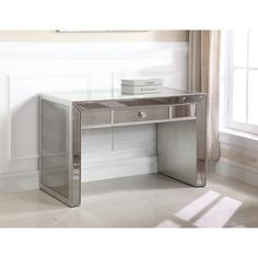 a mirrored desk with two drawers in front of a window and white walls behind it