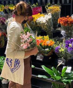 a woman standing in front of a bunch of flowers