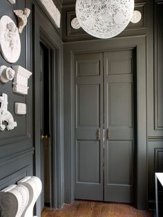 an entryway with gray walls and white decorations on the door, chandelier and toilet paper rolls