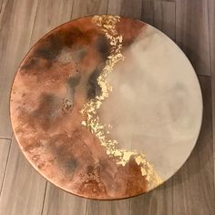 a brown and white plate sitting on top of a wooden floor next to a wall