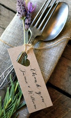 a place setting with a fork, spoon and tag