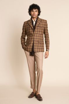 Brown checkered pattern three buttoned single breasted blazer with flap patch pockets.
Components: 1
Neckline: Notched Lapel
Sleeve Type: Full
Fabric: 100% Wool Tweed Checks
Color: Brown
Other Details: 
Horn buttons detailing
 Note: The inner shirt, scarf, pant and the bag carried by the model are not for sale
Occasion: Party - Aza Fashions Checkered Blazer Outfit, 70s Outfits Men, Brown Blazer Outfit, Checkered Blazer, Brown Checkered, Blazer For Men, Blazer Men, Man Blazer, 70s Outfits