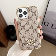 a woman holding up her gucci phone case