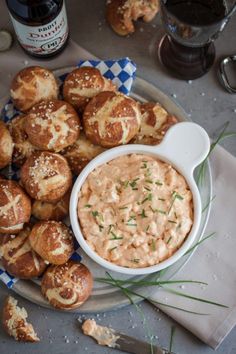 a plate filled with rolls and dip on top of a blue checkered table cloth