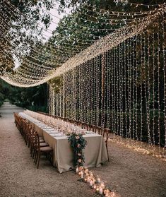 a long table is set up with candles and greenery for an outdoor wedding reception