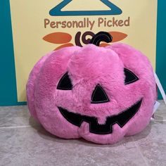 a pink stuffed pumpkin sitting on top of a counter next to a sign that says personally picked