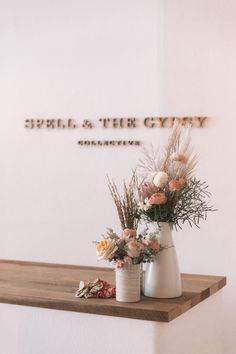 flowers are in vases sitting on a shelf near a sign that says sepella and the city