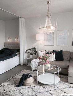 a living room filled with furniture and a chandelier hanging over the top of it