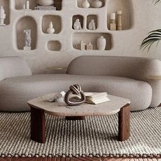 a living room filled with lots of furniture and shelves on the wall next to a coffee table