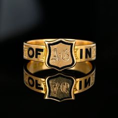 Exquisite and rare Victorian mourning ring band featuring an engraved shield signet front with the band having black enamel spelling out 'In Memory Of'.  Made in England and handcrafted in 16K gold, the black enamel letters are spaced with a fine engraved chased sections.  The inside of the band is engraved with A Gouarne died 10 May 1875 age 16.  This antique piece of mourning jewelry is extremely well crafted with exceptional details.  A museum-quality piece! Materials: 16 Karat Gold, Black Enamel Ring Size: 8 US, Q UK - We do not recommend resizing  Weight: 4.2 grams Hallmarks: Full English hallmarks 16, Birmingham, Letter z for 1874-1875 Condition: Very, very good with the engraving very crisp showing little wear even to the inside of the ring and all enamel intact. Our collection cons Signature Rings, Shield Ring, Ring Antique, Enamel Ring, Unique Antiques, Victorian Jewelry, Jewelry Business, Ring Band, Antique Victorian