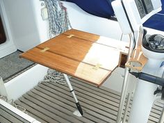 there is a small wooden table on the back of a boat that's docked