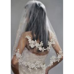 the back of a bride's wedding dress with flowers and pearls on her veil