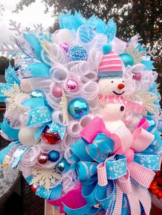 a blue and white christmas wreath with a snowman on it