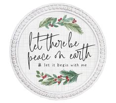 a white plate with the words let there be peace on earth and holly wreaths