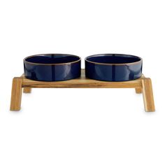 two blue bowls sitting on top of a wooden stand