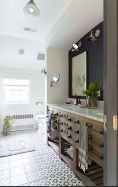 a bathroom with a sink, mirror and tiled floor