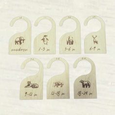 six wooden baby bibs with animals on them and numbers for each one in the middle