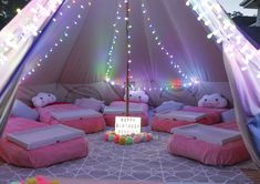 a tent with lots of pillows and lights on it