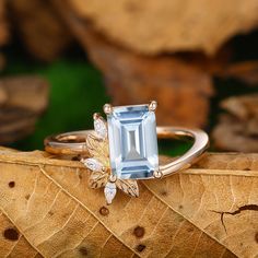 a ring with an aqua topazte surrounded by leaves