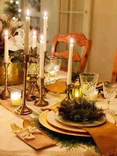 a dining room table set with candles and place settings