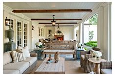 a living room filled with lots of furniture next to a fire place in a house