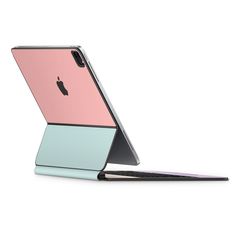 an open laptop computer sitting on top of a white surface with a pink and blue cover