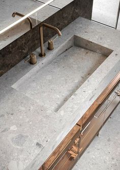 a bathroom sink sitting under a mirror next to a faucet in a bathroom