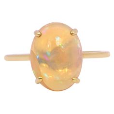 18 Karat Yellow Gold 3.71 Carat Opal Solitaire Ring This statement Opal Ring draws its inspiration from the Moon. Featuring an Oval-Cut Opal and set in a Four-Prong Setting, it glistens like the moon. Finished with a yellow gold band for a seamless finish this ring is meant to bring a sense of wonder to even the simplest of your outfits. Wear it solo as your everyday essentials and make a gracious statement throughout the day. This ring is a part of the exclusive collection by Gems Paradise, which is exclusively designed and expertly crafted by the senior-most artisans in our ateliers of Jaipur. Details of the piece: Gross Weight: 2.749 grams Opal: 3.71 carats Gold: 2.007 grams Note: The ring size can be changed within a few hours. This piece can be manufactured in any precious or semi-pre Antique Opal Ring, Rose Gold Opal Ring, Opal Solitaire Ring, Precious Stones Rings, Opal Ring, Jewelry Vintage, Gold Band, Everyday Essentials, Opal Rings