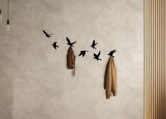 there are birds flying over the coat rack