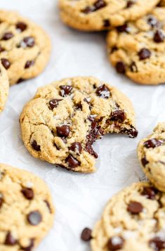 chocolate chip cookies on parchment paper with one broken in half