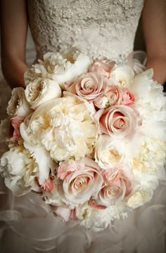 a bride holding a bouquet of white and pink flowers