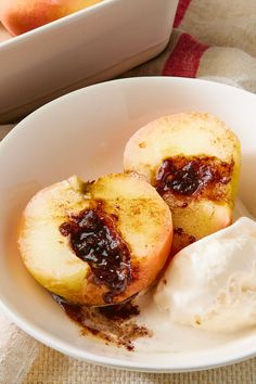 two pieces of fruit in a bowl with ice cream on the side next to it