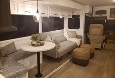 a living area with couches, tables and chairs in an airstream style home