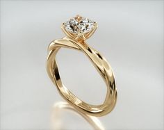 a yellow gold engagement ring with a twisted band and a round diamond in the center