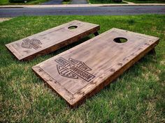 two wooden boards sitting in the grass with logos on them and one is made out of wood