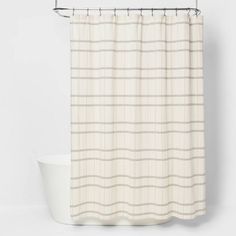 a shower curtain with a white and beige checkerboard pattern on the bottom, next to a bathtub